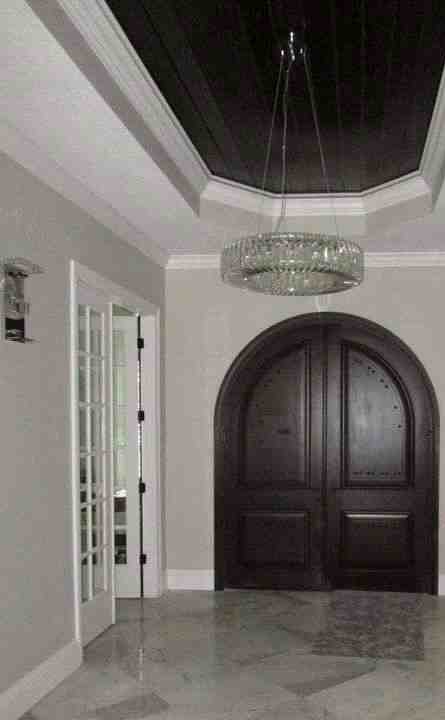 Foyer with arched wood double doors and wood-plank tray ceiling, North Tampa custom home