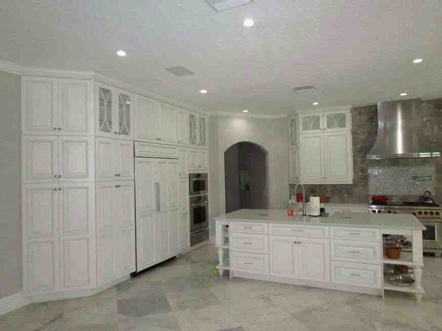 Custom kitchen with white cabinetry, island and stainless range hood, North Tampa